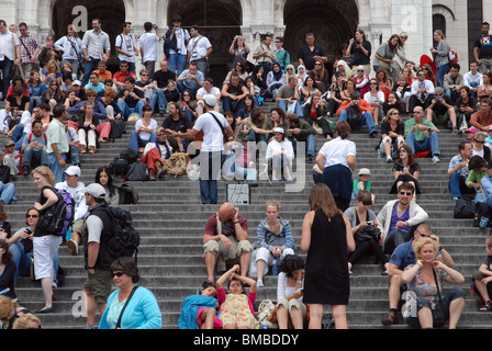 Tourists on the steps in front of  the Sacré-Coeur Basilica church. Montmartre, Paris. Stock Photo
