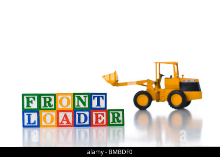 Colorful children's blocks spelling FRONT LOADER with a toy tractor Stock Photo