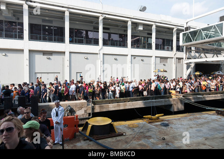dense diverse queue of patient people waiting to visit USS Iwo Jima snakes along Pier 88 during fleet week in New York City Stock Photo