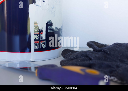 Close-up abstract of paint tin, gloves and scraper. Stock Photo