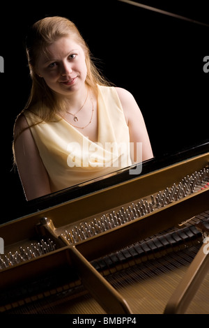 beautiful girl playing the grand piano, isolated on black Stock Photo