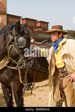 Cowboy standing next to his horse in the old west Stock Photo