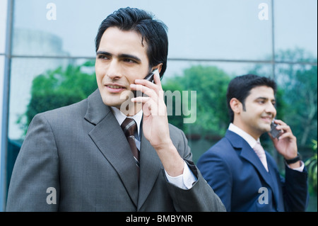 Two businessmen talking on mobile phones Stock Photo