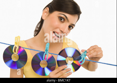 Woman hanging CDs on a clothesline Stock Photo