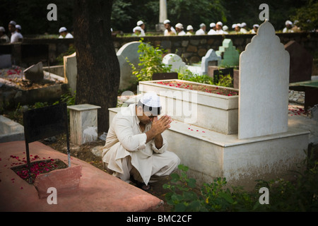 Man praying at a grave in a cemetery, Old Delhi, India Stock Photo