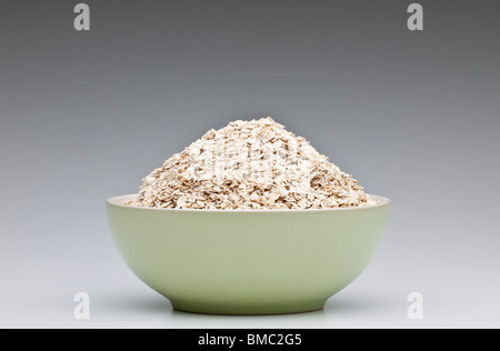Green breakfast bowl heaped full of porridge oats Stock Photo