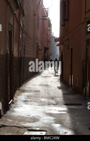 Man on bike in narrow street in Medina , Marrakesh , Morocco , North Africa Stock Photo