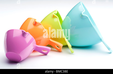 Four Plastic Measuring Cups Laid On A White Background Stock Photo