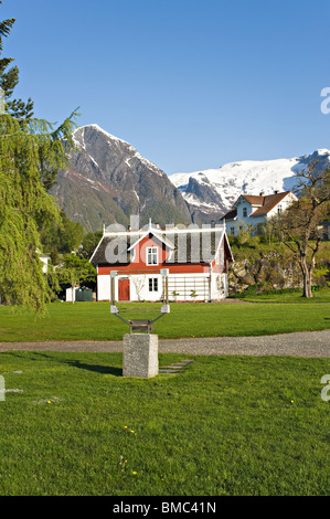 Small Norwegian House in Grounds of Kviknes Hotel Balestrand with Snow Covered Mountain Peaks Sognefjord Norway Stock Photo