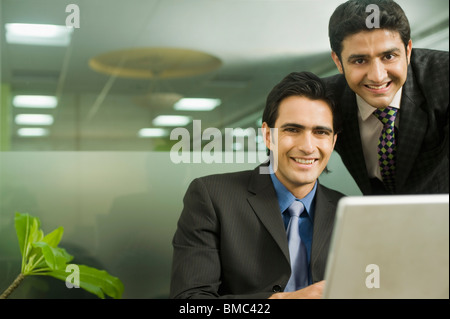 Two businessmen working on a laptop Stock Photo
