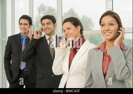 Business executives talking on mobile phones Stock Photo