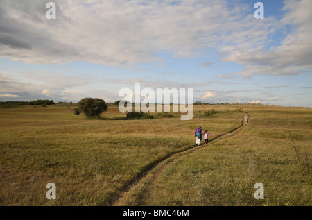 An older couple and a young girl hiking in the prairie. Stock Photo
