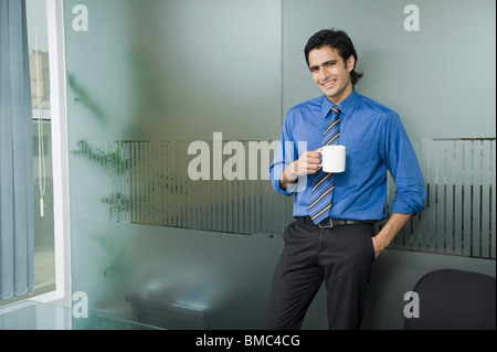 Businessman having a cup of tea in an office Stock Photo