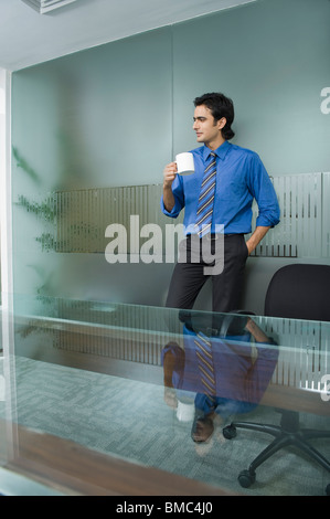Businessman having a cup of tea in an office Stock Photo