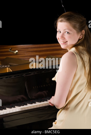 beautiful girl playing the grand piano, isolated on black Stock Photo