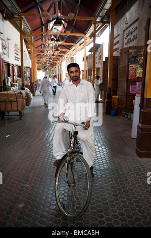 Asian man on a bicycle in Dubai's spice souk Stock Photo