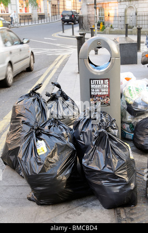 Rubbish bags await collection by Council services on the roadside in a central Dublin Street Ireland Stock Photo