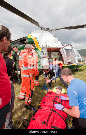 A great north air ambulance above Grasmere, Lake District, UK with members of Langdale/Ambleside mountain Rescue Team. Stock Photo