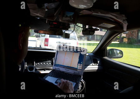 Nebraska State Trooper using laptop computer in cruiser to read output from an Automated License Plate Reader, LPR. Stock Photo