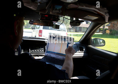 Nebraska State Trooper using laptop computer in cruiser to read output from an Automated License Plate Reader, LPR. Stock Photo