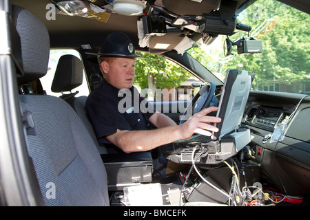 Nebraska State Trooper using laptop computer in cruiser to read output from an Automated License Plate Reader, LPR. Stock Photo