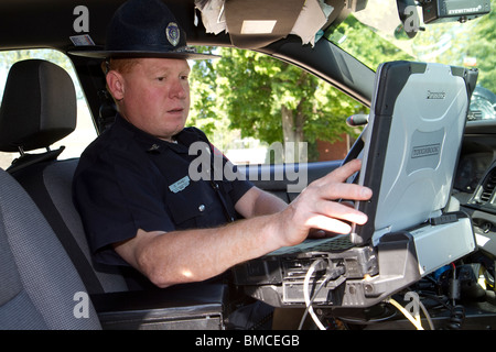 Nebraska State Trooper using laptop computer in cruiser to read output from an Automated License Plate Reader, LPR. Stock Photo