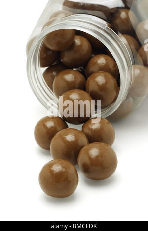 Chocolate balls spilled out from plastic container Stock Photo