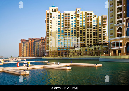 Apartment blocks on one of the fronds on the Palm Island Jumeirah in Dubai overlooking a newly built marina Stock Photo