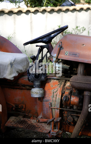 Old fashioned gas mask hanging from tractor steering wheel Stock Photo