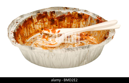 Plastic white knife and fork sitting in an aluminum tray take out tray emptied of its food contents. Stock Photo