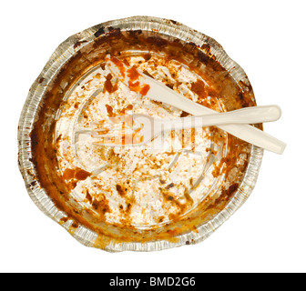 Plastic white knife and fork sitting in an aluminum tray take out tray emptied of its food contents. Photographed from above. Stock Photo