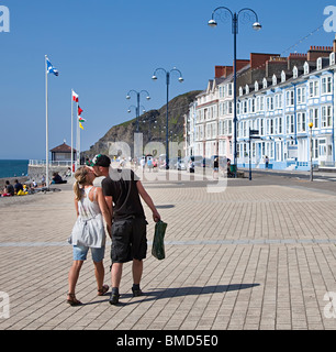 Couple kissing while walking on sea front promenade Aberystwyth Wales UK Stock Photo