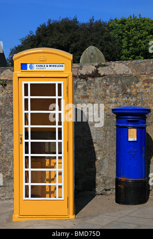 Yellow telephone box and blue letter box on High Street, St. Anne, Alderney, Channel Island, United Kingdom Stock Photo