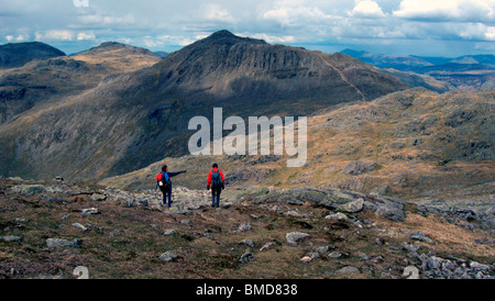 Two walkers heading towards Three Tarns and Bow Fell, Lake District, Cumbria, UK. Stock Photo