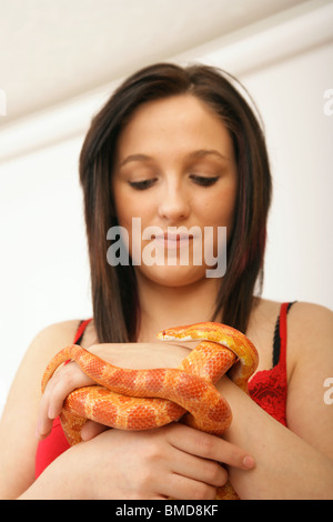 A Woman looking at a corn snake held in her hand Stock Photo