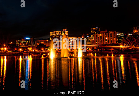 Orlando Florida Skyline at night taken from Lake Lucerne looking north with beautiful fountains lit in the evening Stock Photo