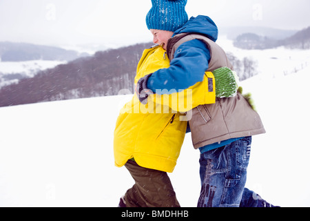Two Boys Roughhousing Outdoors in Winter Stock Photo
