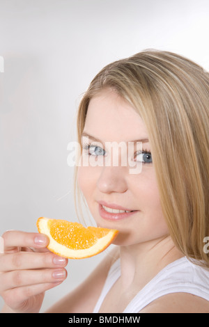 Woman Eating Slice of Orange Stock Photo