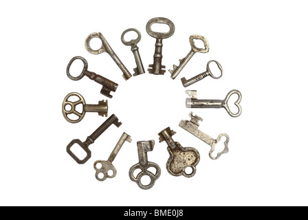 A collection of 13  antique silver skeleton keys isolated in a circle with white background. Some are hollow with many designs in the handles. Stock Photo