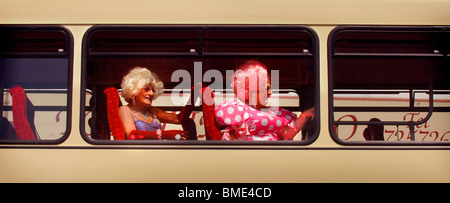 Two drag queens, Maisie Trolette and Miss Jason on a Brighton double decker bus. Stock Photo