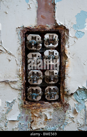 Cover Missing and Exposed Wiring of a light Switch in a Derelict Asylum Stock Photo