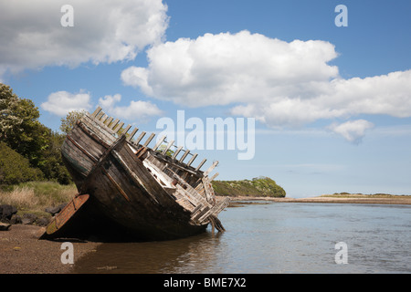 Old wooden hull of a ship wreck on seashore in bay's tidal lagoon at Traeth Dulas, Isle of Anglesey (Ynys Mon), North Wales, UK Stock Photo