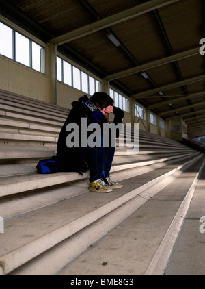 Boy sitting on staircase in depression Stock Photo