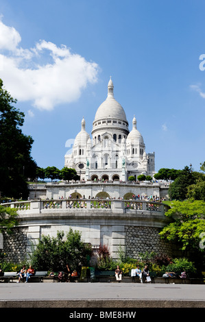 Tourists sitting in front of white domed church Stock Photo