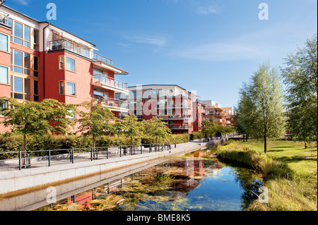 Buildings and tree reflected in canal Stock Photo