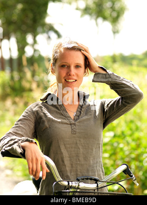 Smiling woman with bicycle, portrait Stock Photo