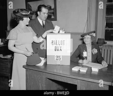 Vintage 1930s photo of a man and woman placing their votes in a ballot box in Washington DC as an election official looks on. Stock Photo