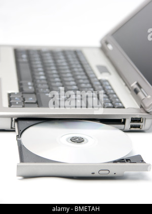 cd or dvd disk in the drive of a laptop Stock Photo