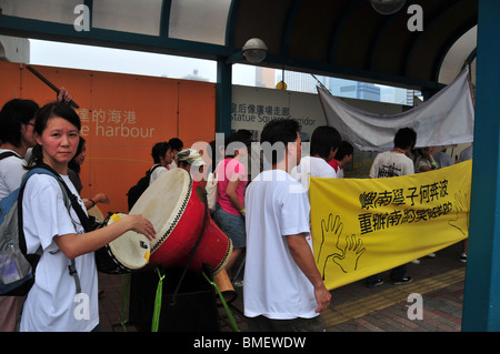 People, beating drums and holding placards, demonstrating against a bus terminal closure, Central Waterfront, Hong Kong Stock Photo