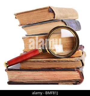 Stack of books and magnifying glass isolated on white background Stock Photo